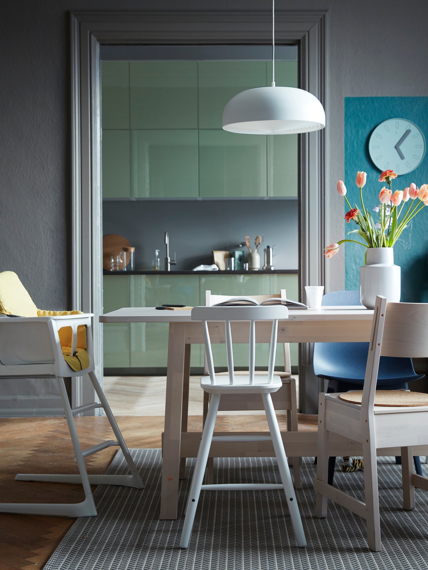 Ein Hochstuhl für Babys und ein Kleinkinderhochstuhl stehen an einem Esstisch.