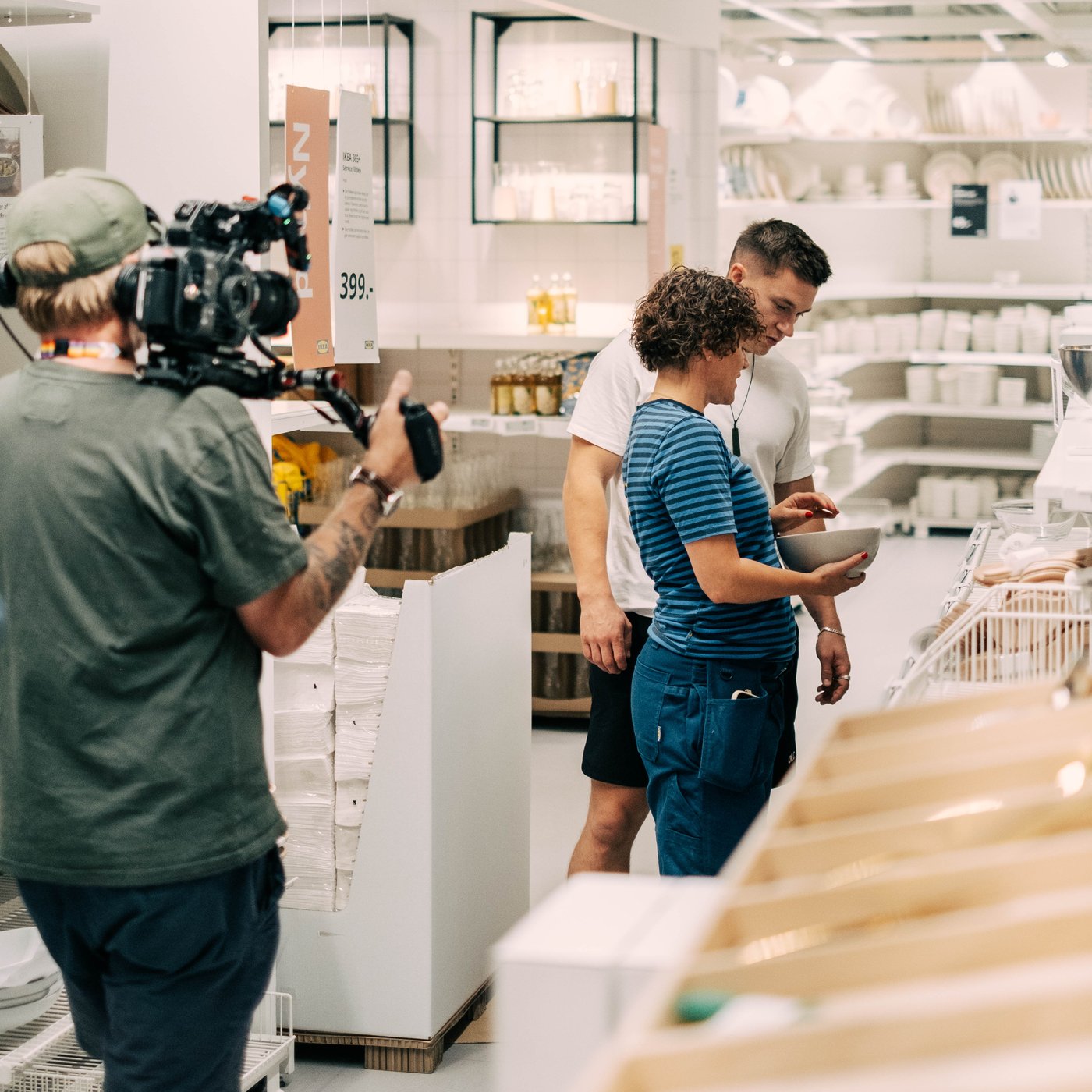 En optagelse fra "Hvem vinder hjem?" TV-programmet, hvor en indretter taler med én af deltagerne i et IKEA varehus. Til venstre i billedet kan ses en kameramand.