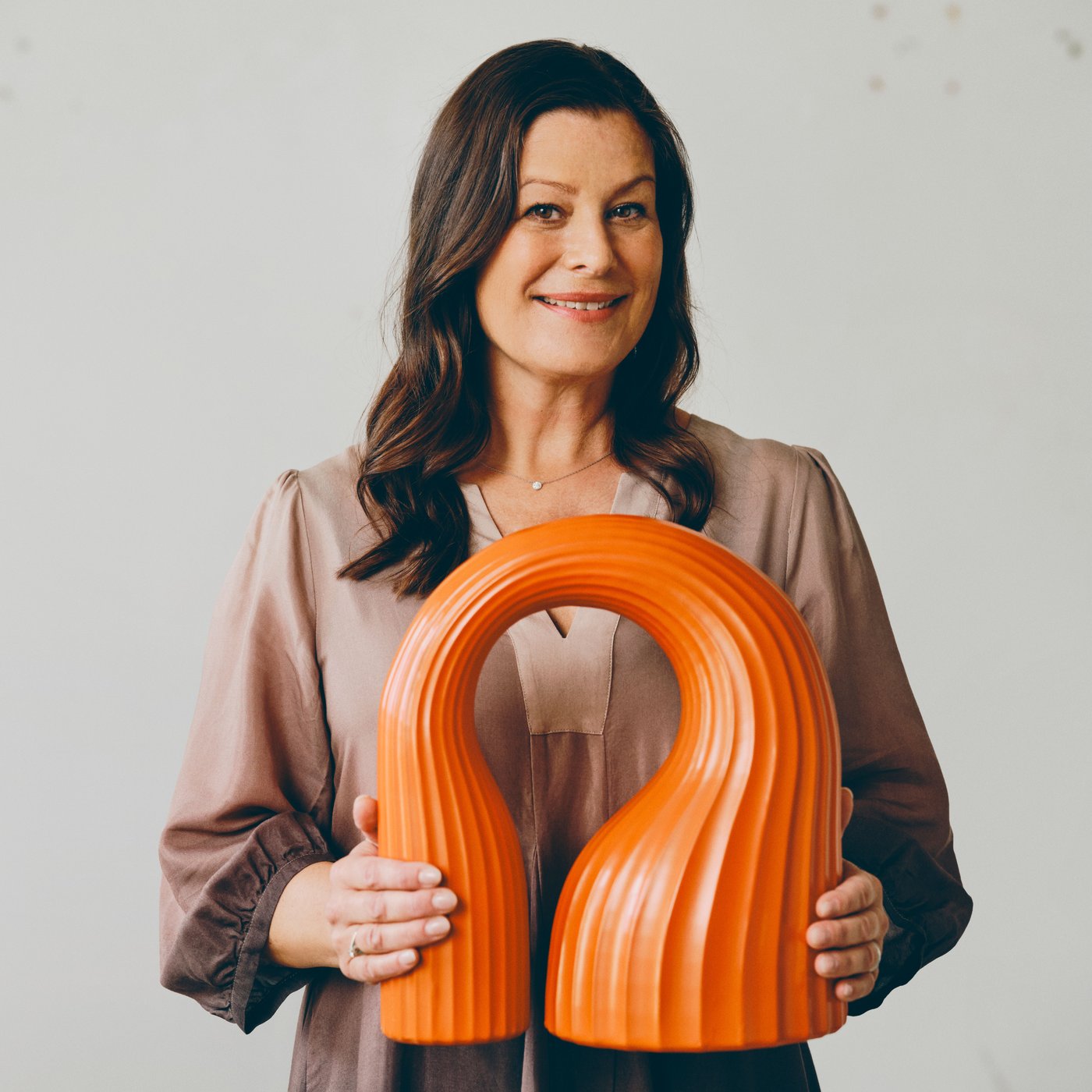 Närbild av Lisa Hilland holidig en orange skulptur gjord för IKEA KONSTRUDA konstsamling.