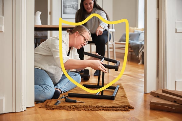 Two women building furniture in their home. 