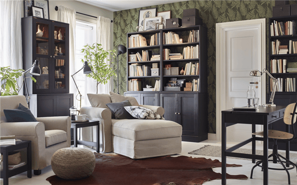 Two light beige IKEA GRÖNLID armchairs in a living room with HAVSTA dark brown glass cabinets and shelves.