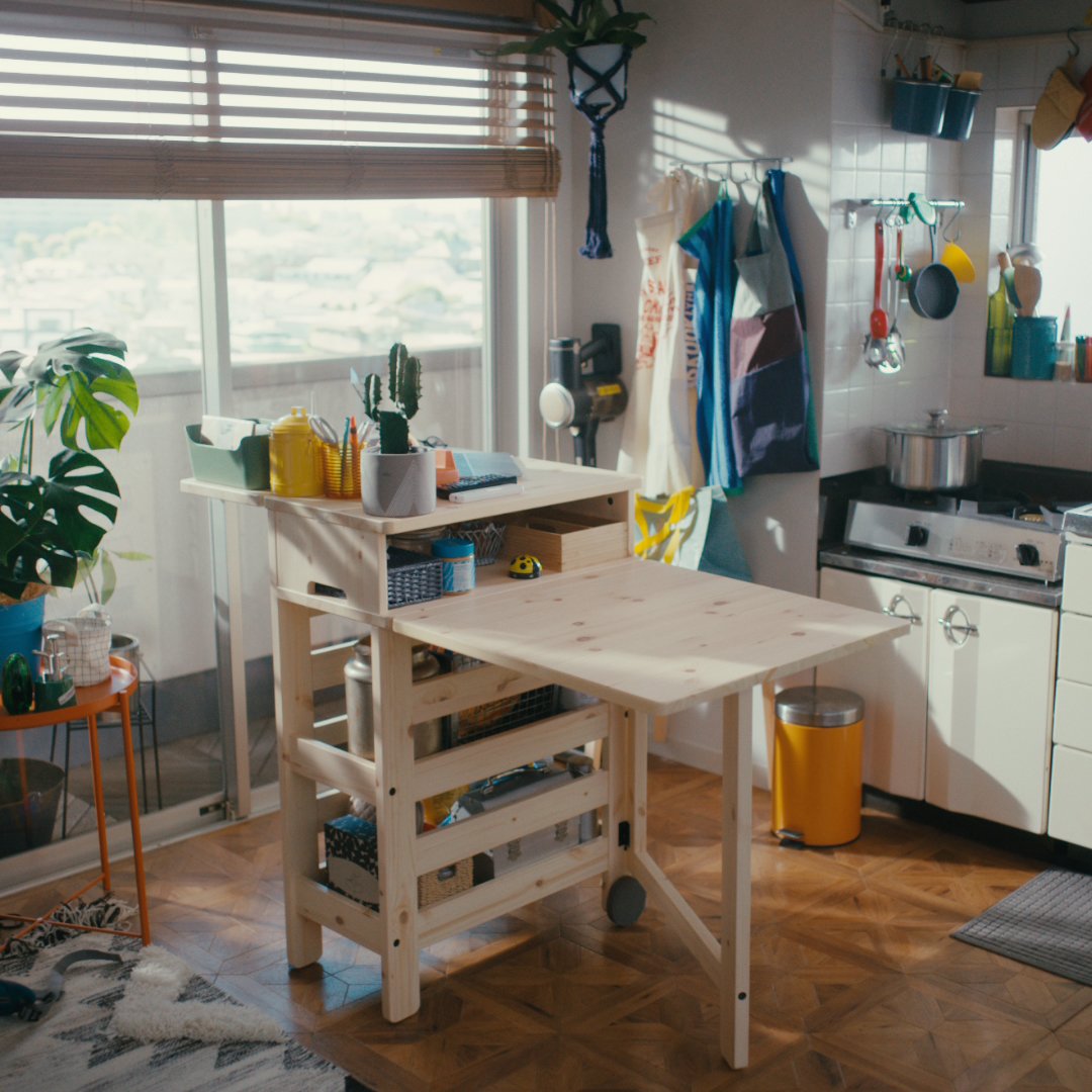 Bright kitchen with wooden table and potted plants by the window
