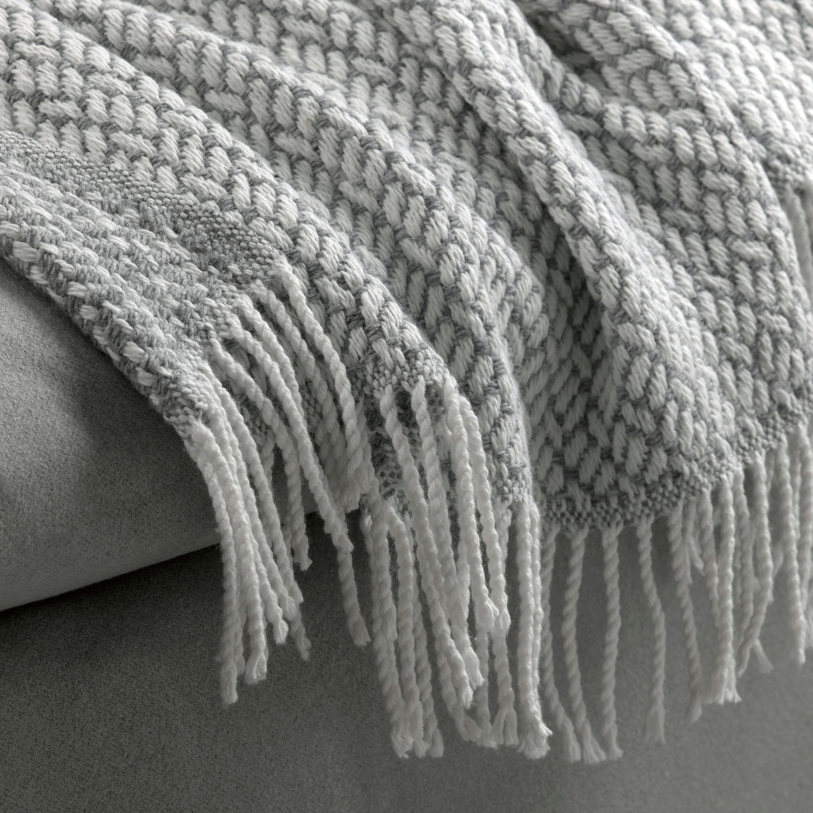 A grey MAJINGER throw