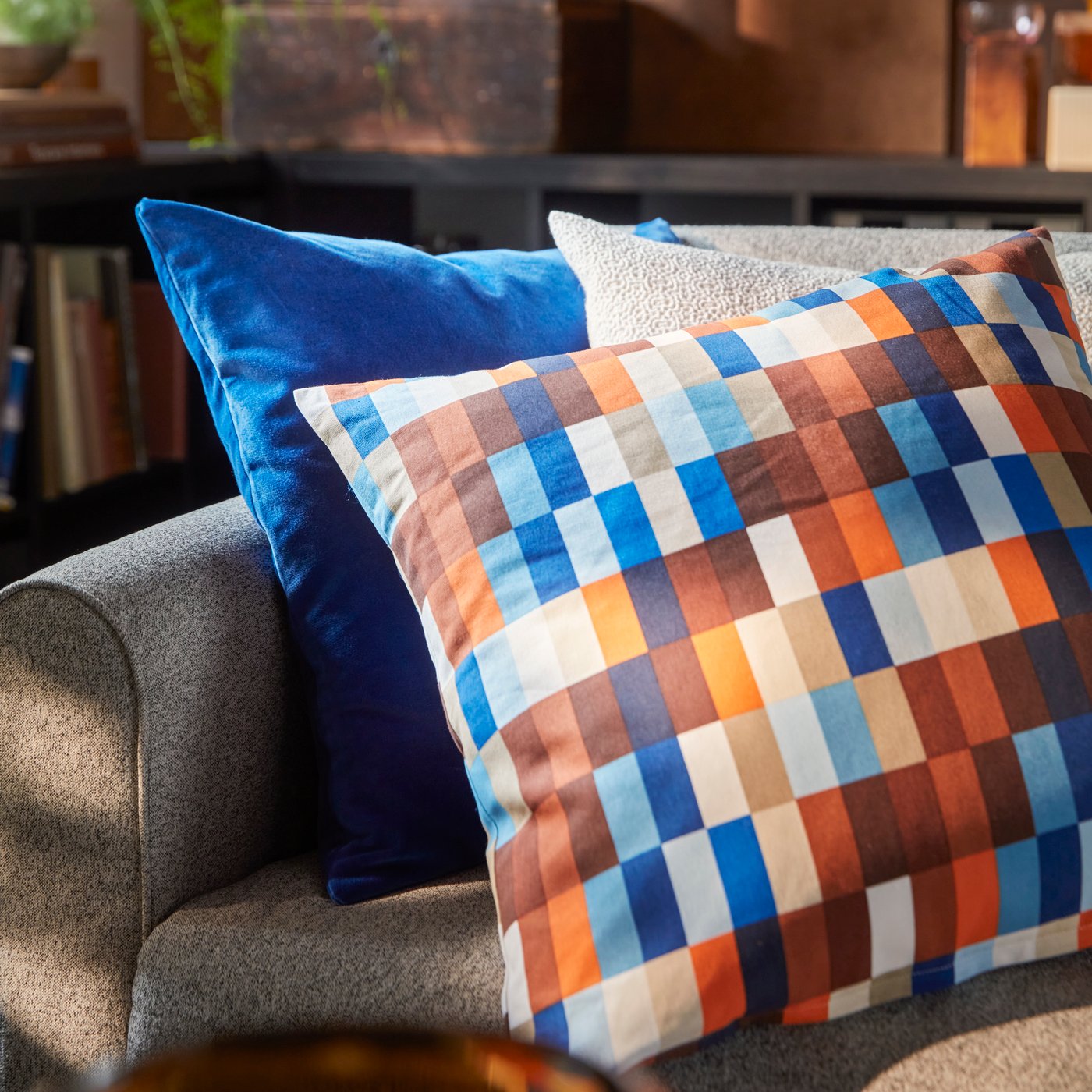 صورة مقربة لكنبة 3 مقاعد SALTMYRAN وغطاء وسادة LÖVNATURSKOG بلون بني/أزرق ووسادتين أخريين.