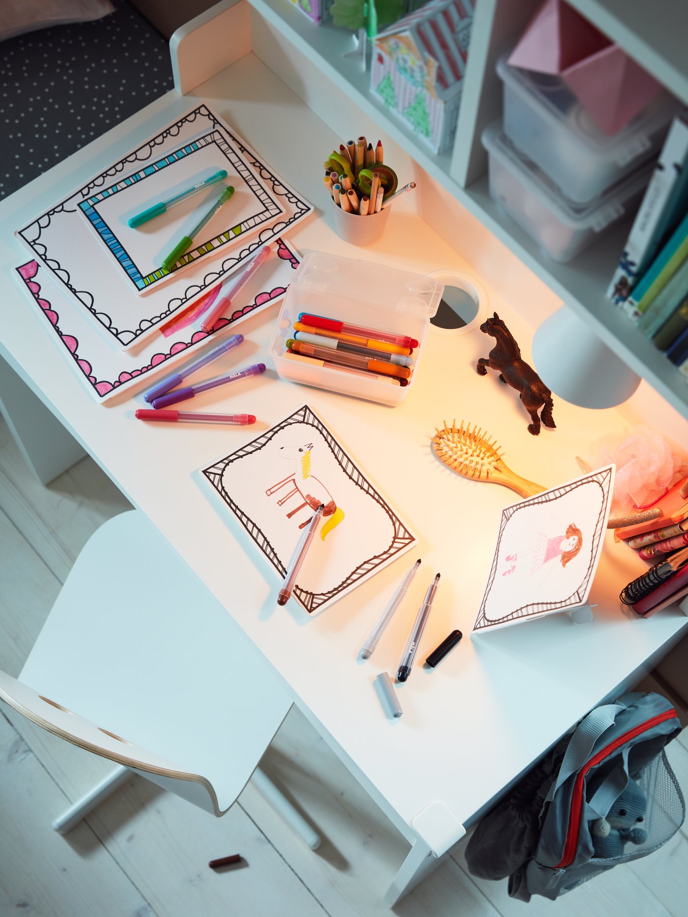 Habitación para bebés y niños con varios marcos negros de cartones hechos con papel, colocados sobre un escritorio.