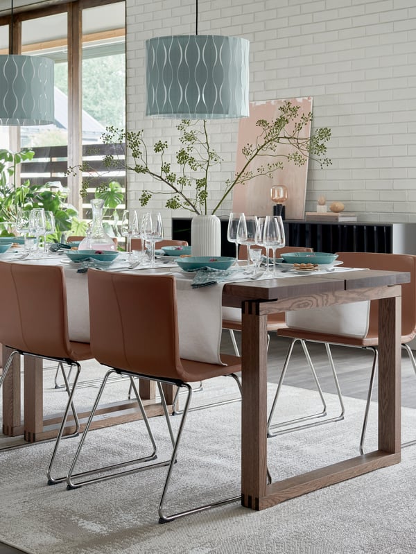 A LERHAMN table is decorated with dinnerware and flowers for a festive meal, with a RÅSKOG trolley at its side.
