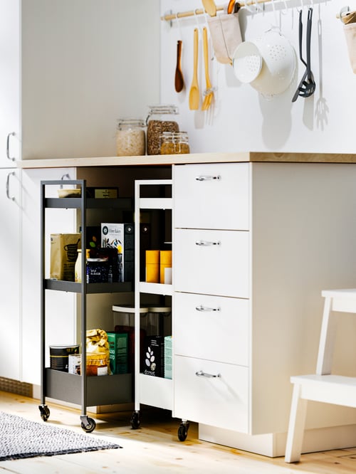 Kitchen focus of a brown base cabinet with fronts, and low and middle drawers, two trolleys, and a step stool.
