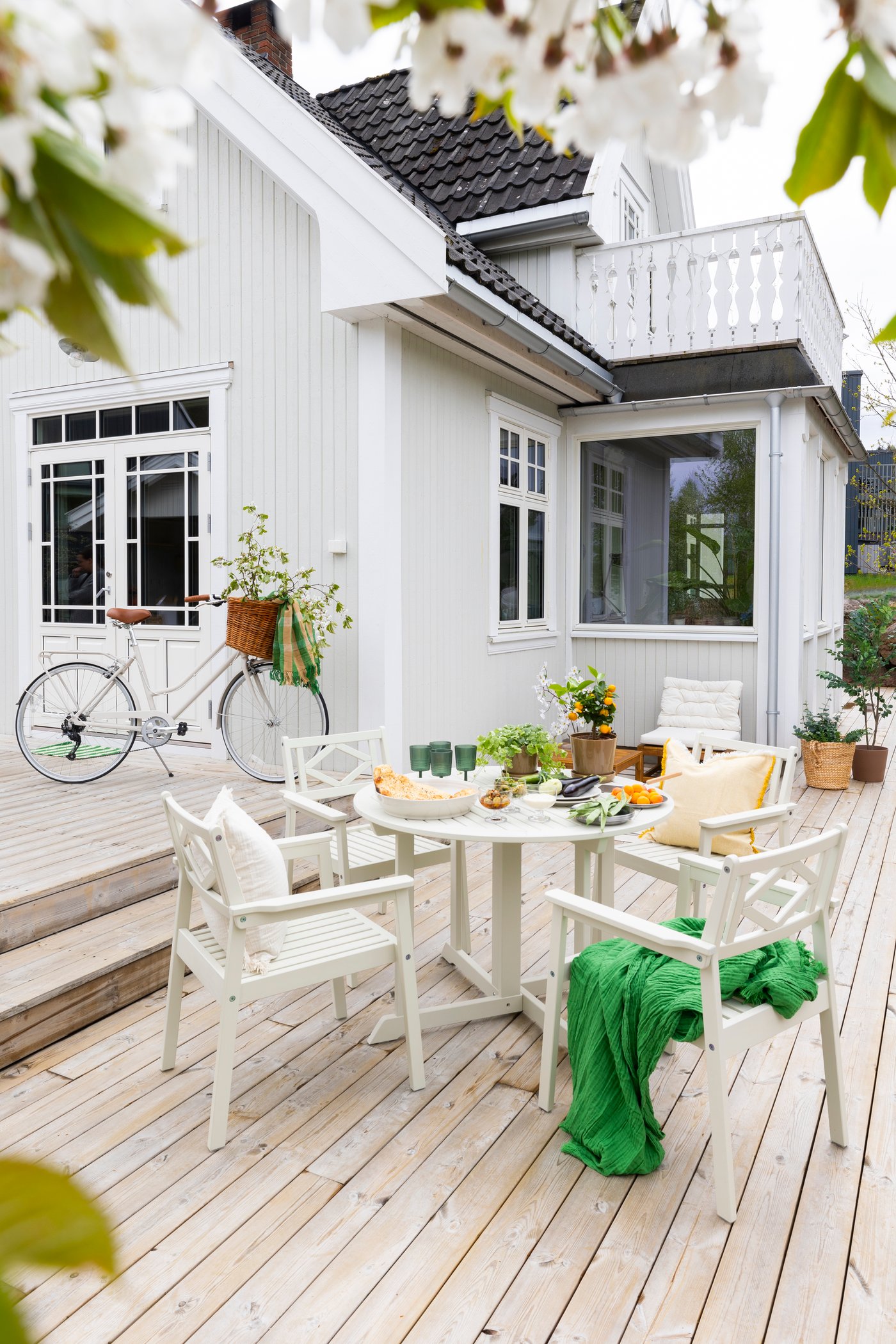 A white/beige BONDHOLMEN chair with armrests, outdoor