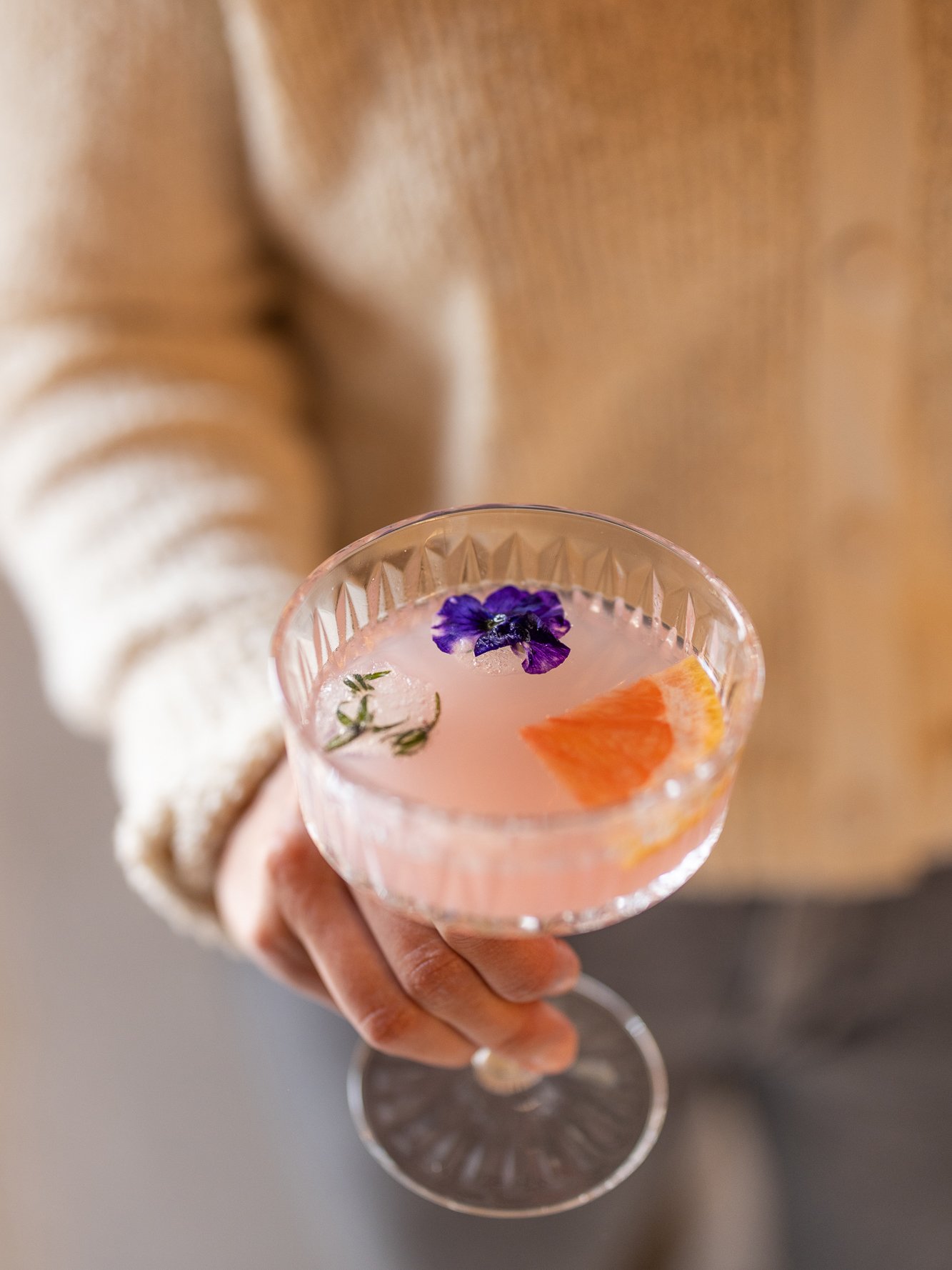 A person is holding a beautiful midsummer drink in his hand.