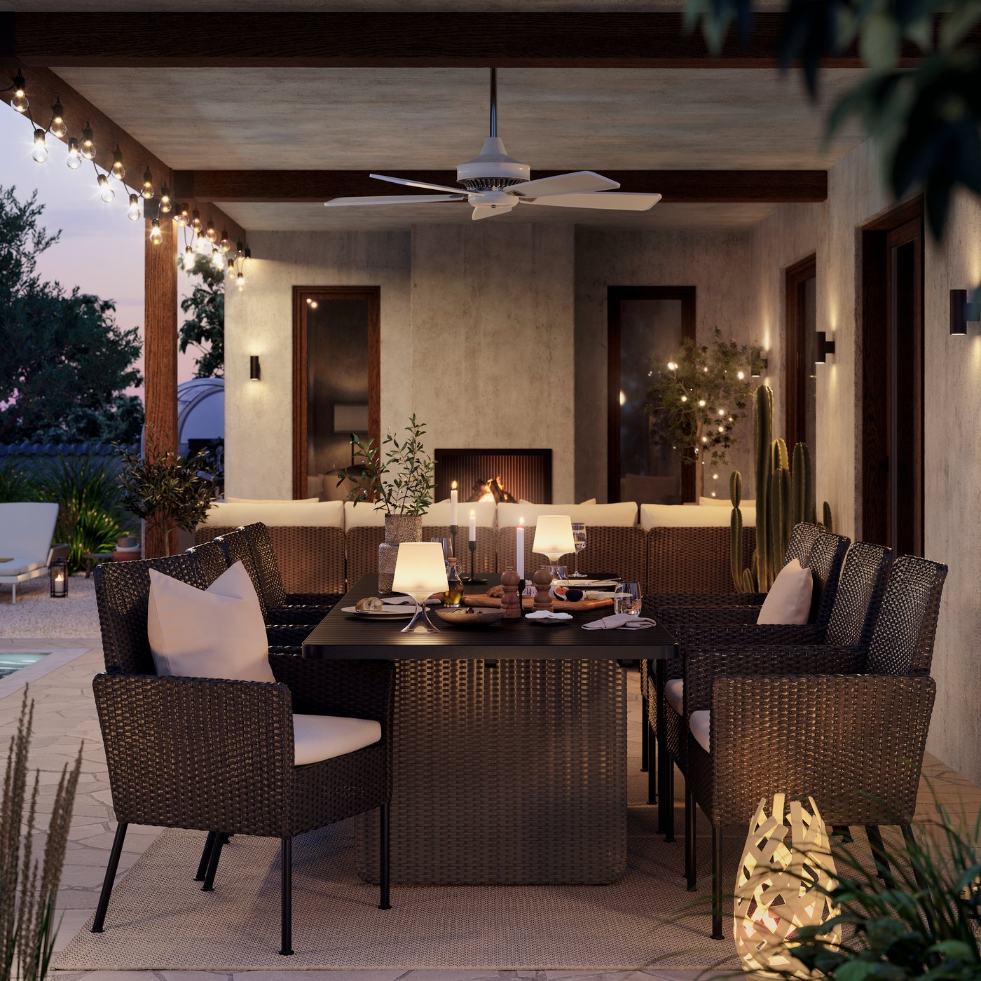 En utomhusmatplats i kvällsljus med sex mörkgrå VITTSKÄR matstolar med kuddar och ett matchande bord.