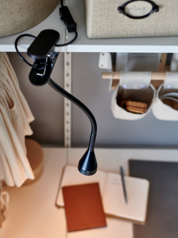 A black NÄVLINGE LED clamp spotlight in the home office