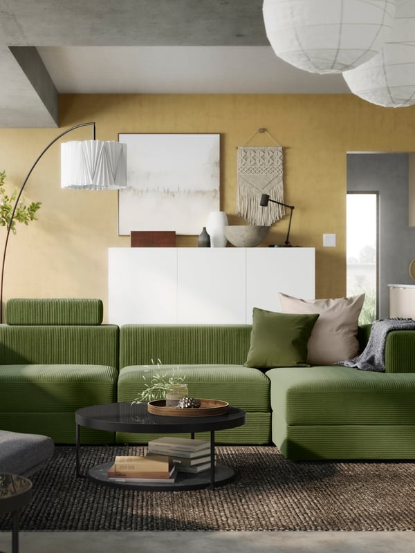 Avarassa olohuoneessa on suuri vihreänkeltainen JÄTTEBO-moduulisohva.