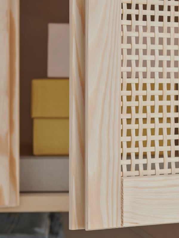 A close-up of the light bamboo IVAR door standing ajar in the light pine frame of IVAR storage system.