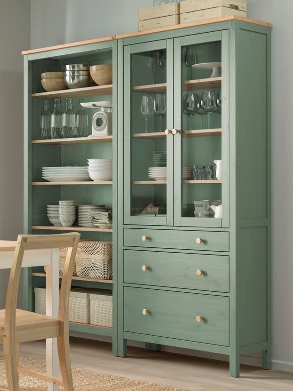 A grey-green/light brown stained HEMNES storage combination w doors/drawers in the dining room