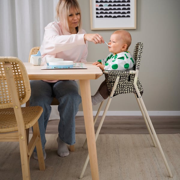 A beige/anthracite SANDKATT highchair with tray in the dining room