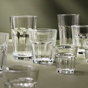 Kilka kieliszków POKAL w różnych rozmiarach ustawiono na miękkiej, szarozielonej powierzchni.