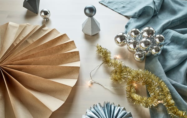Aus IKEA Weihnachtsdekorationen wie VINTER 2017 Girlande goldfarben, silberfarbenen Geschenkboxen und Weihnachtskugeln, Geschenkpapier und Co. lassen sich wunderbare Dekorationen für Silvester zaubern. Wir zeigen dir, wie du sie in Wanddeko, Tischdeko und Faltblumen aus Papier verwandelst.