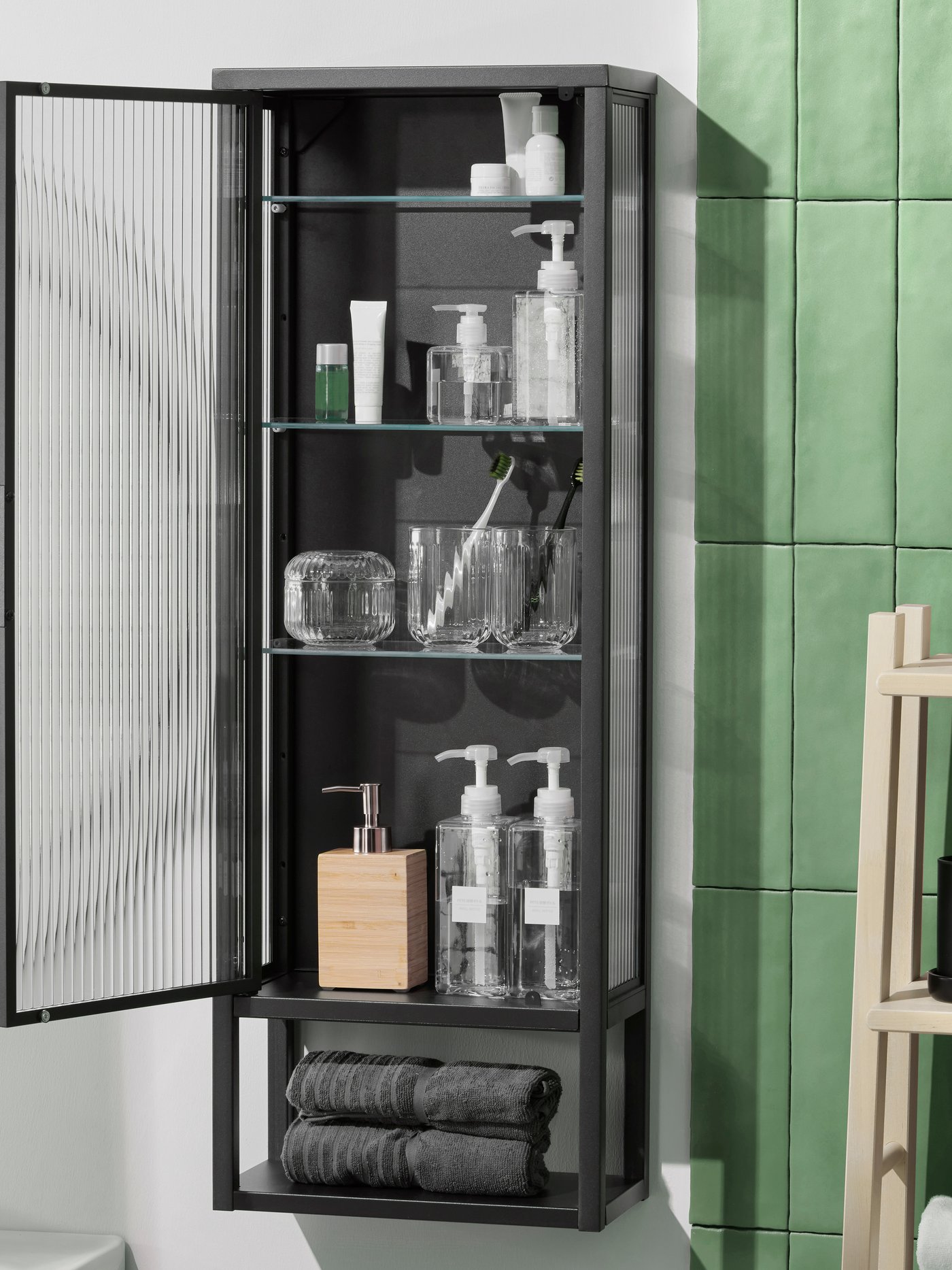 An anthracite MOSSJÖN wall cabinet w shelves/glass door in the bathroom