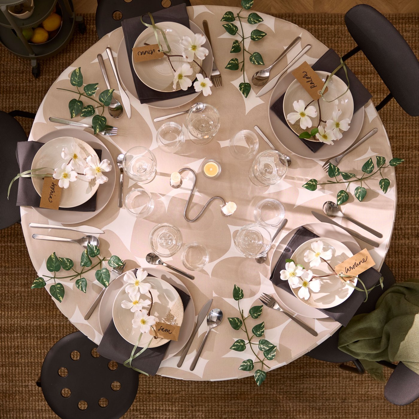 An aerial view of a white DOCKSTA table set for dining, adorned with floral decorations and glasses.