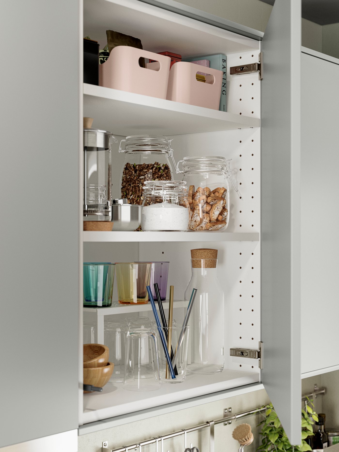 Un mueble de cocina con frentes HAVSTORP en gris claro, con tarros de cristal llenos de alimentos y una hilera de vasos.