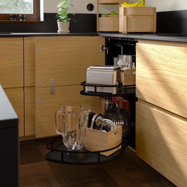 Kitchen storage with the corner door open to display an UTRUSTA corner base cabinet pull-out fitting with diverse appliances.