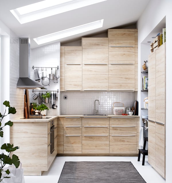 Cuisine en bois clair en forme de U sous un plafond incliné