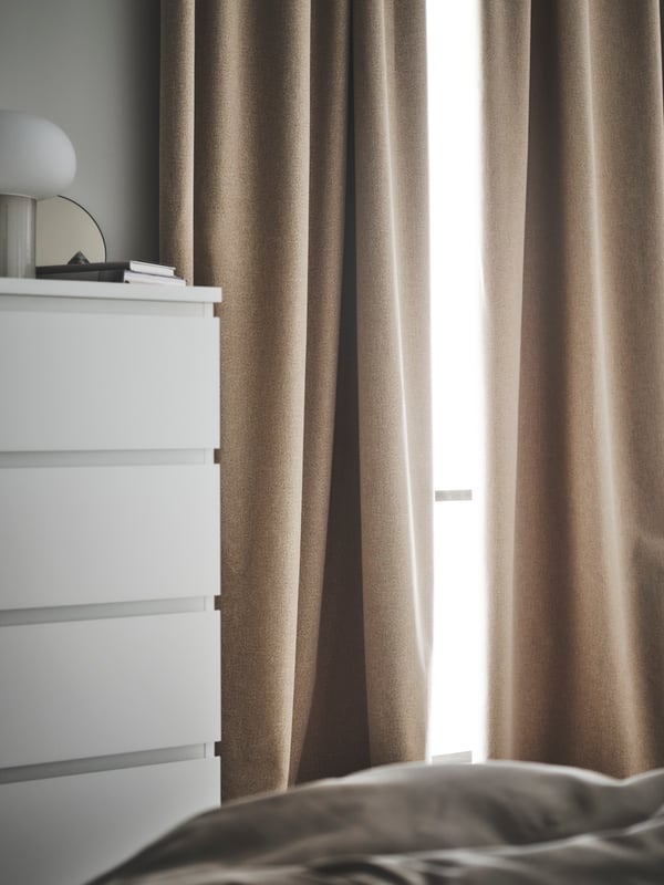A chest of drawers and a window with ROSENMANDEL room darkening curtain in yellow beige wool-like mélange effect.