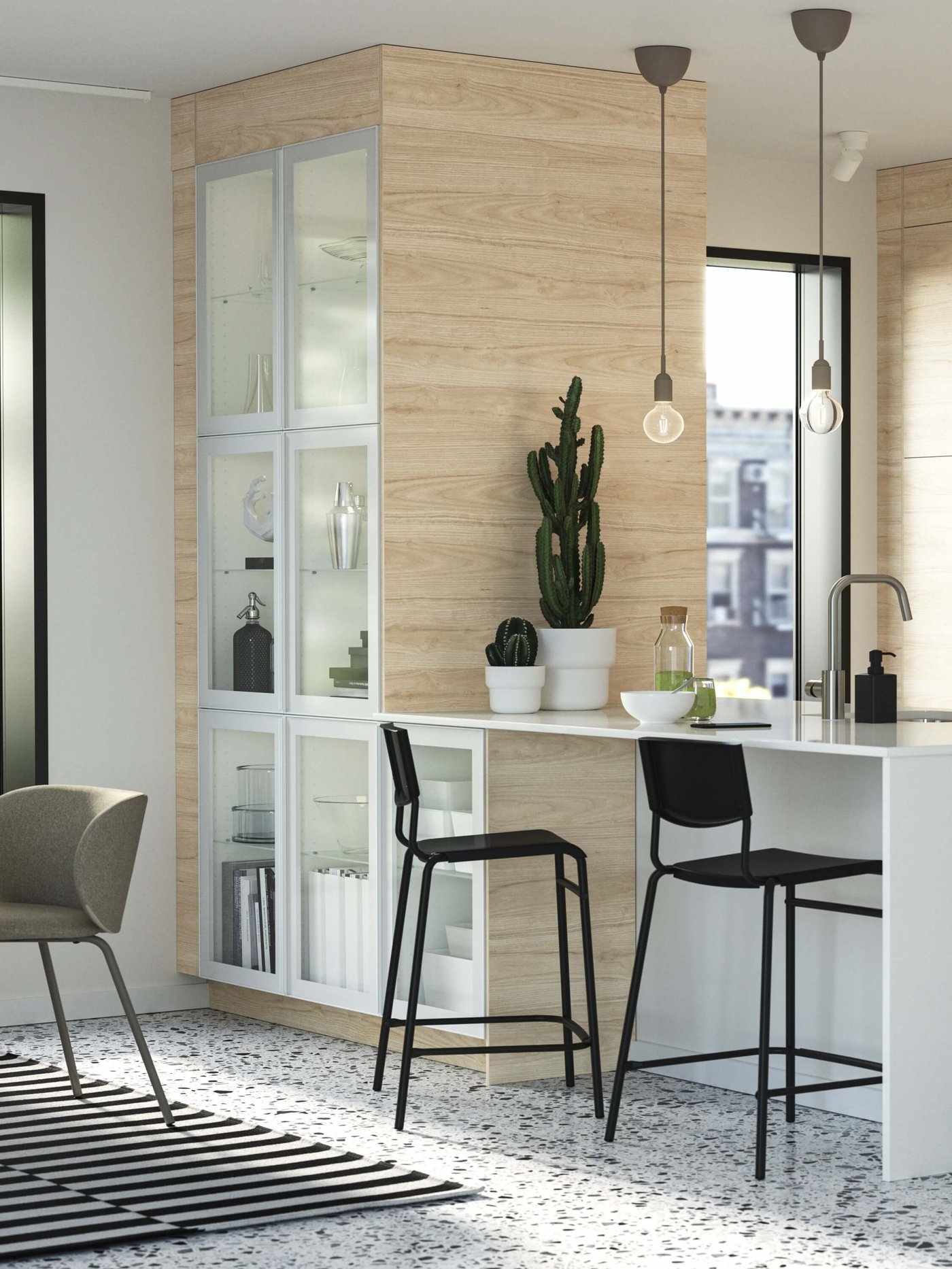 Kitchen island with wood cabinetry, glass shelves, black stools, pendant lights and cactus.