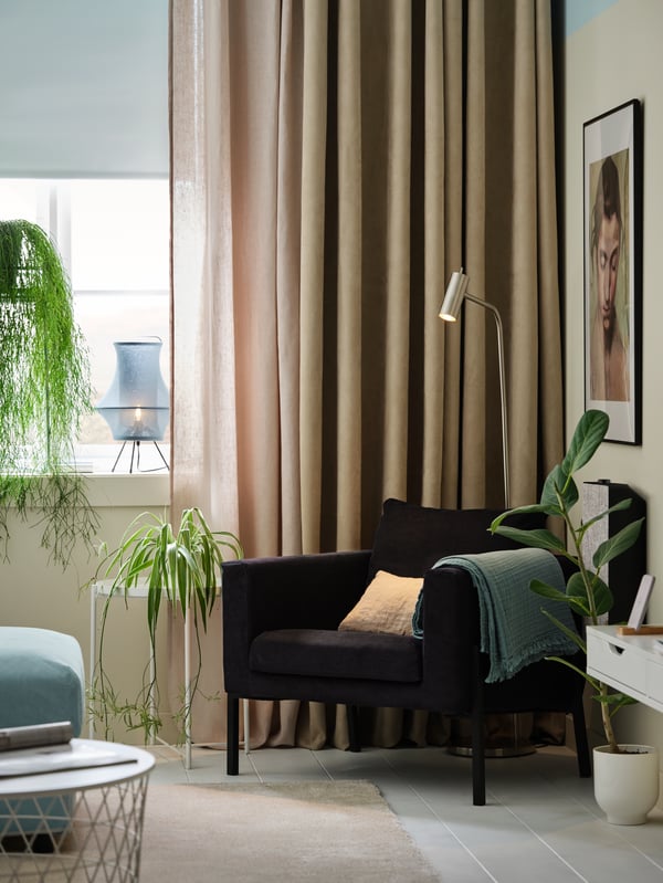 Een kamer met drie lagen raambekleding voor het raam. Een FRIDANS rolgordijn, een DYTÅG gordijn en een BIRTNA gordijn.