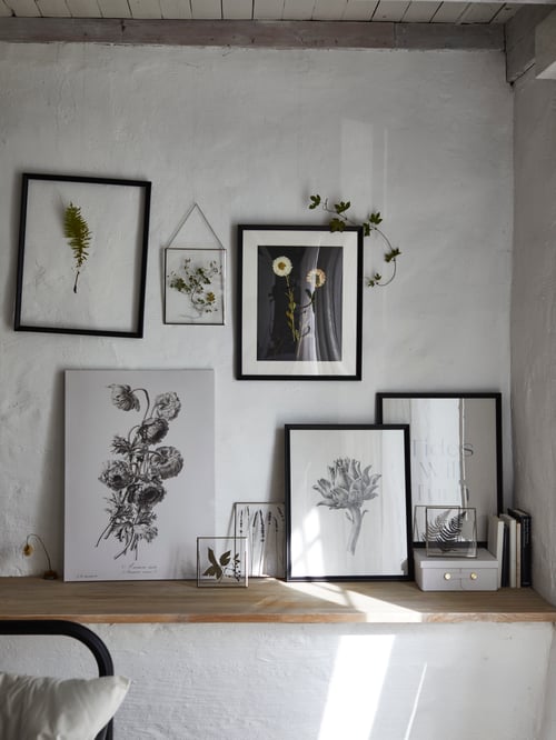 A living room featuring a black KNOPPÄNG frame next to a PJÄTTERYD picture and a KNOPPÄNG frame with poster.