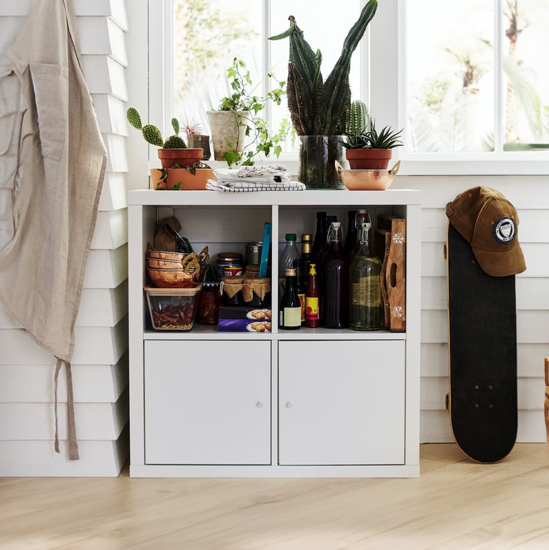 A white KALLAX shelving unit with doors in the hallway