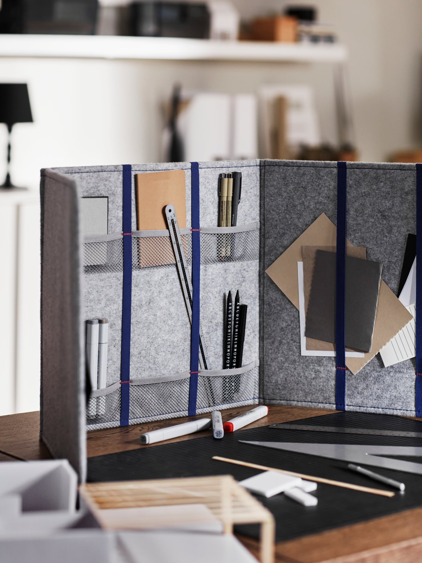 A close-up of a screened off study and workspace area created by placing ÖVNING desk divider on top of a dining table.