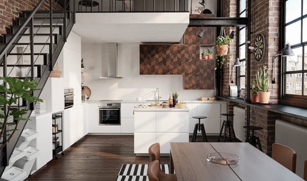 Ampia cucina bianca con ante e frontali cassetto bianco opaco, piano di lavoro bianco e tavolo marrone scuro con due sedie - IKEA