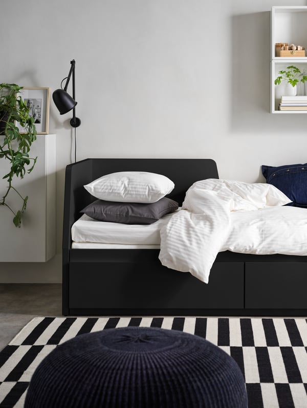 A black SKURUP work/wall lamp in the bedroom