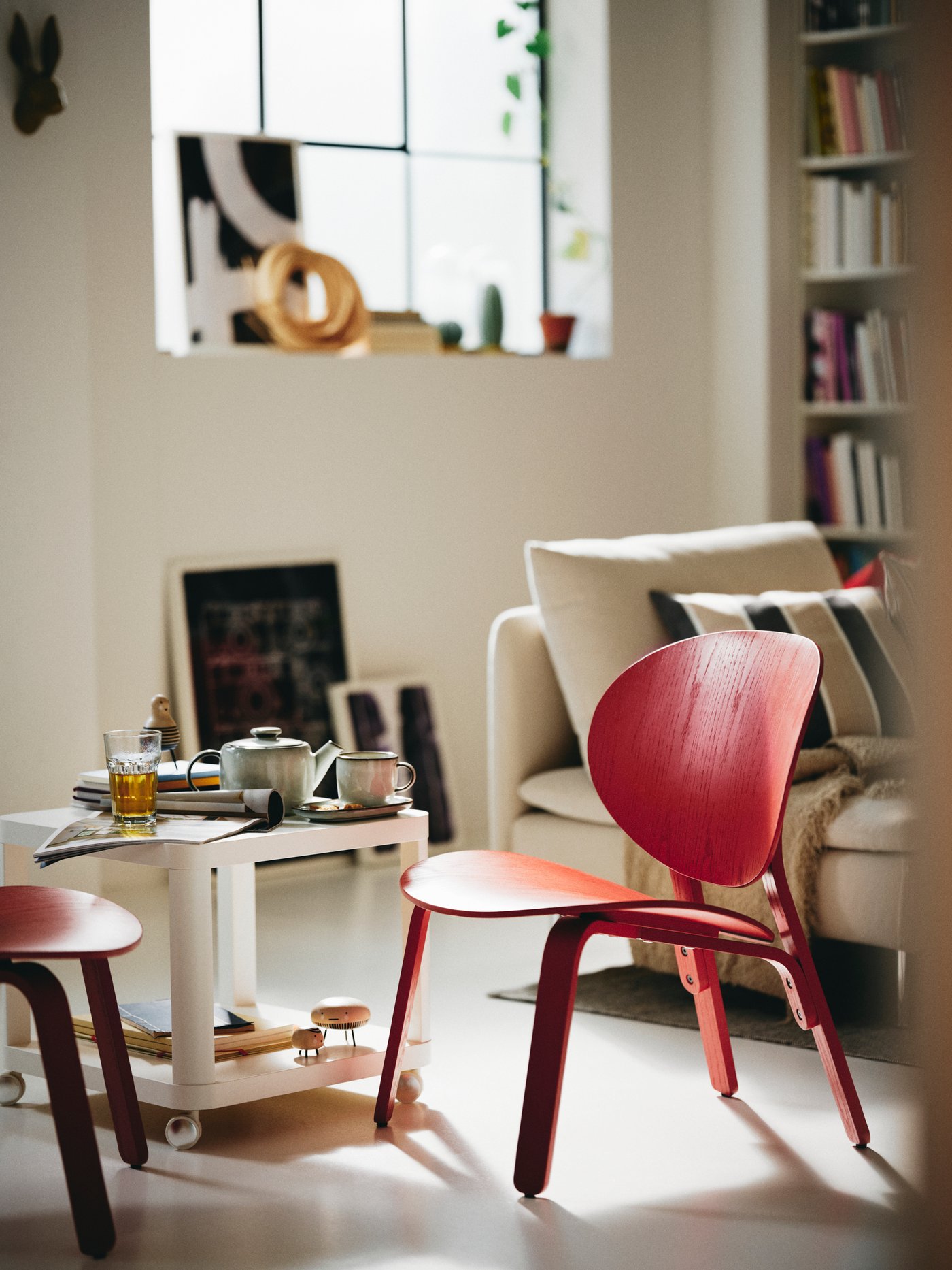 En röd stol är placerad i ett mitten av ett vitt rum.