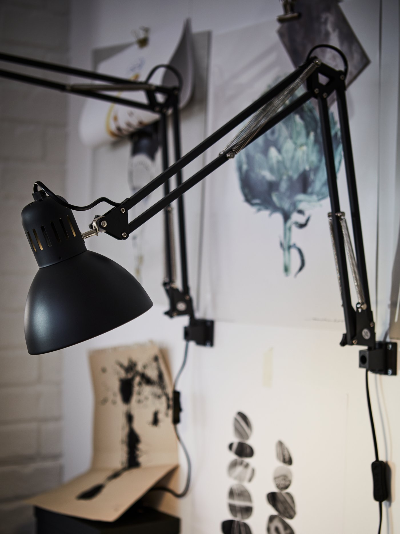 A dark grey TERTIAL work lamp in a home office
