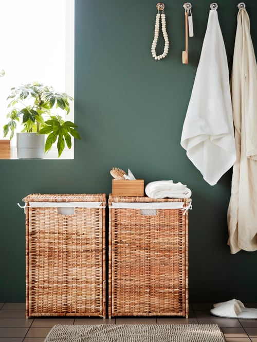 Bathroom featuring 2 rectangular laundry baskets with lining made of rattan, a 4 piece bathroom set and a terry bath towel.