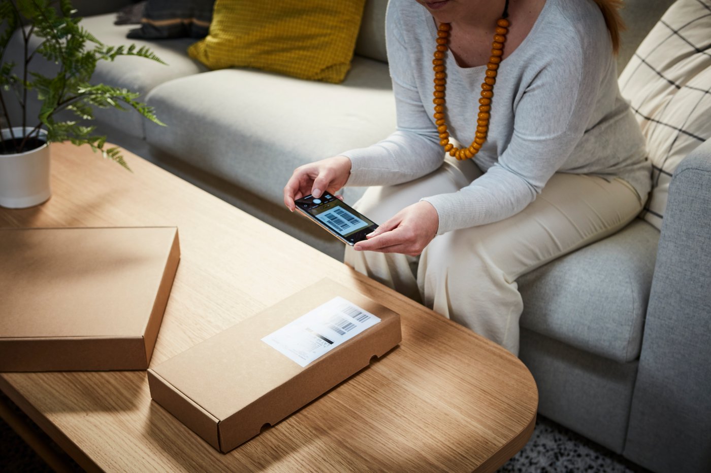 A lady scanning a QRcode on a box. 