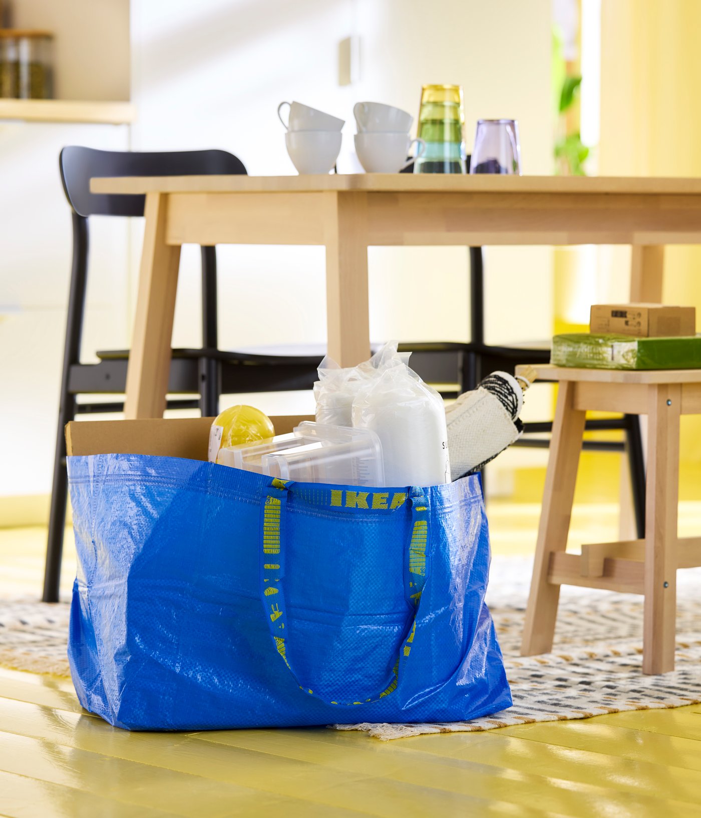 A blue FRAKTA carrier bag, large in the dining room
