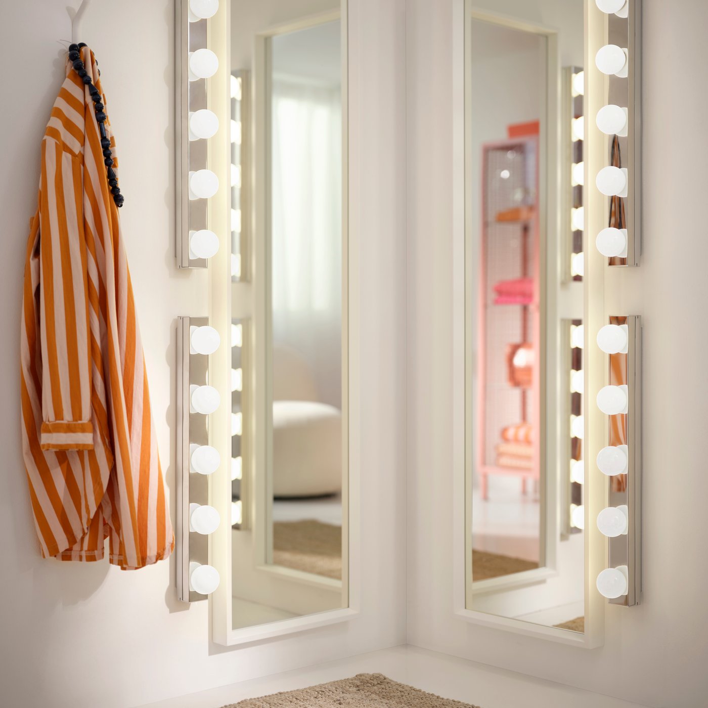 Two NISSEDAL mirrors mounted in corner, surrounded lamps and striped shirt on a hook.