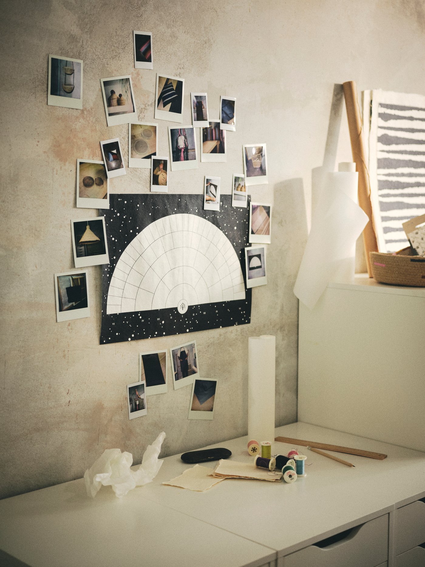 Polaroid dan poster dinding kertas mulberi MÄVINN dengan lukisan pohon keluarga digantung pada dinding di atas unit laci.