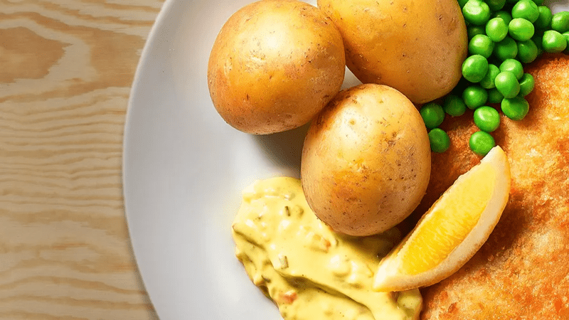 Panerad spätta med remouladsås på en tallrik