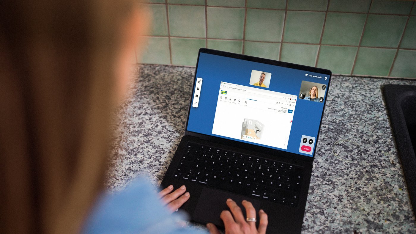 A person uses a laptop for online IKEA kitchen planning, reviewing a digital kitchen layout while consulting remotely with an IKEA kitchen expert through a video meeting.
