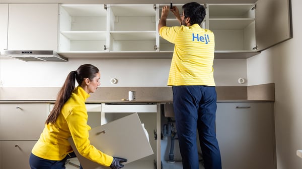 Praconik i pracowniczka IKEA montujący kuchnie u klienta