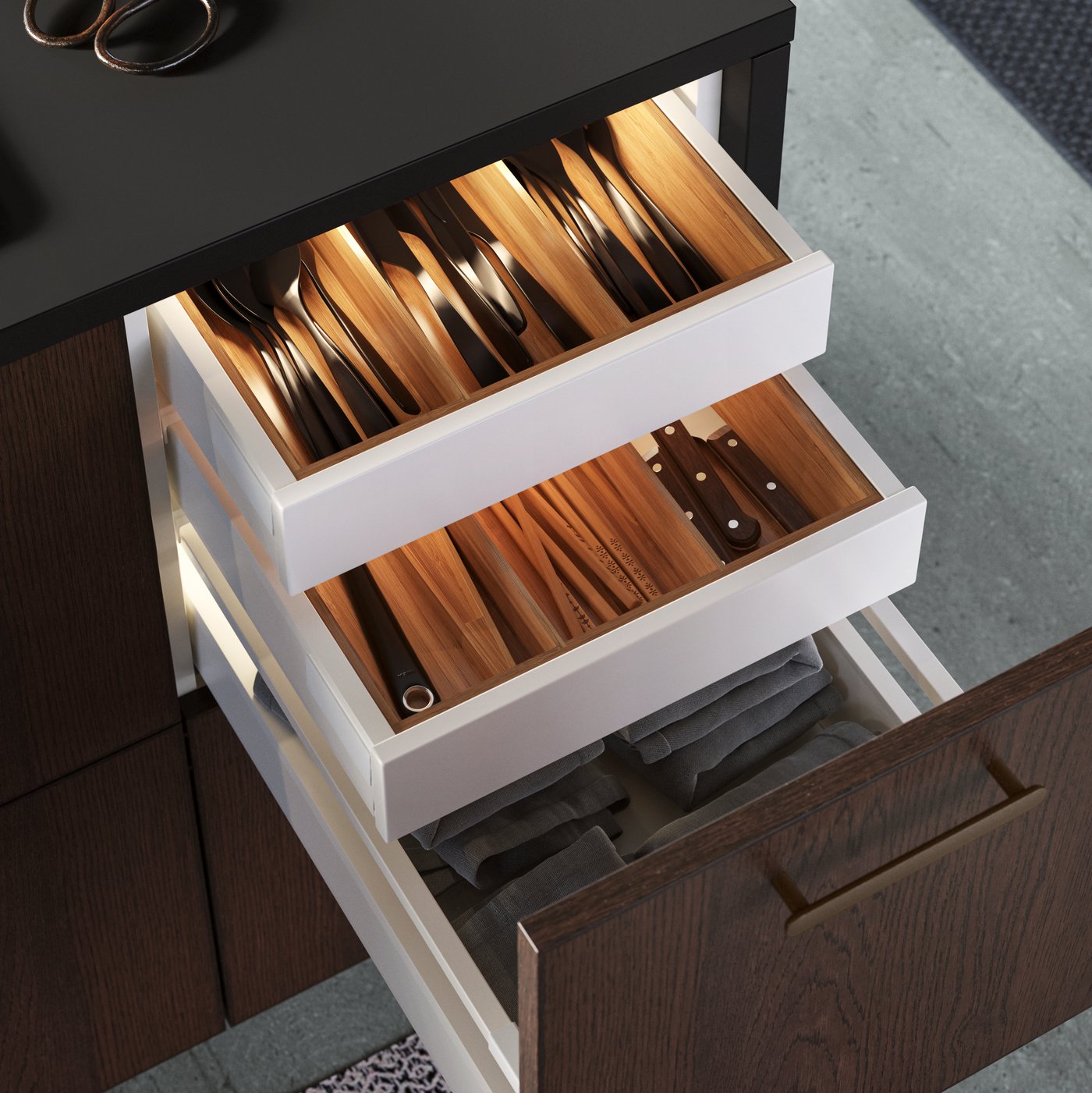 En åpen kjøkkenskuff med flere innvendige skuffer. 