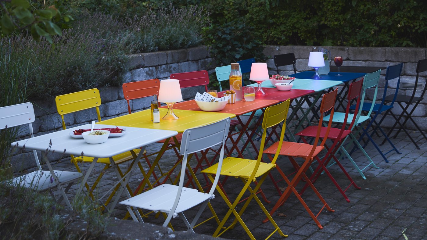 A light green outdoor SUNDSÖ folding chair outside