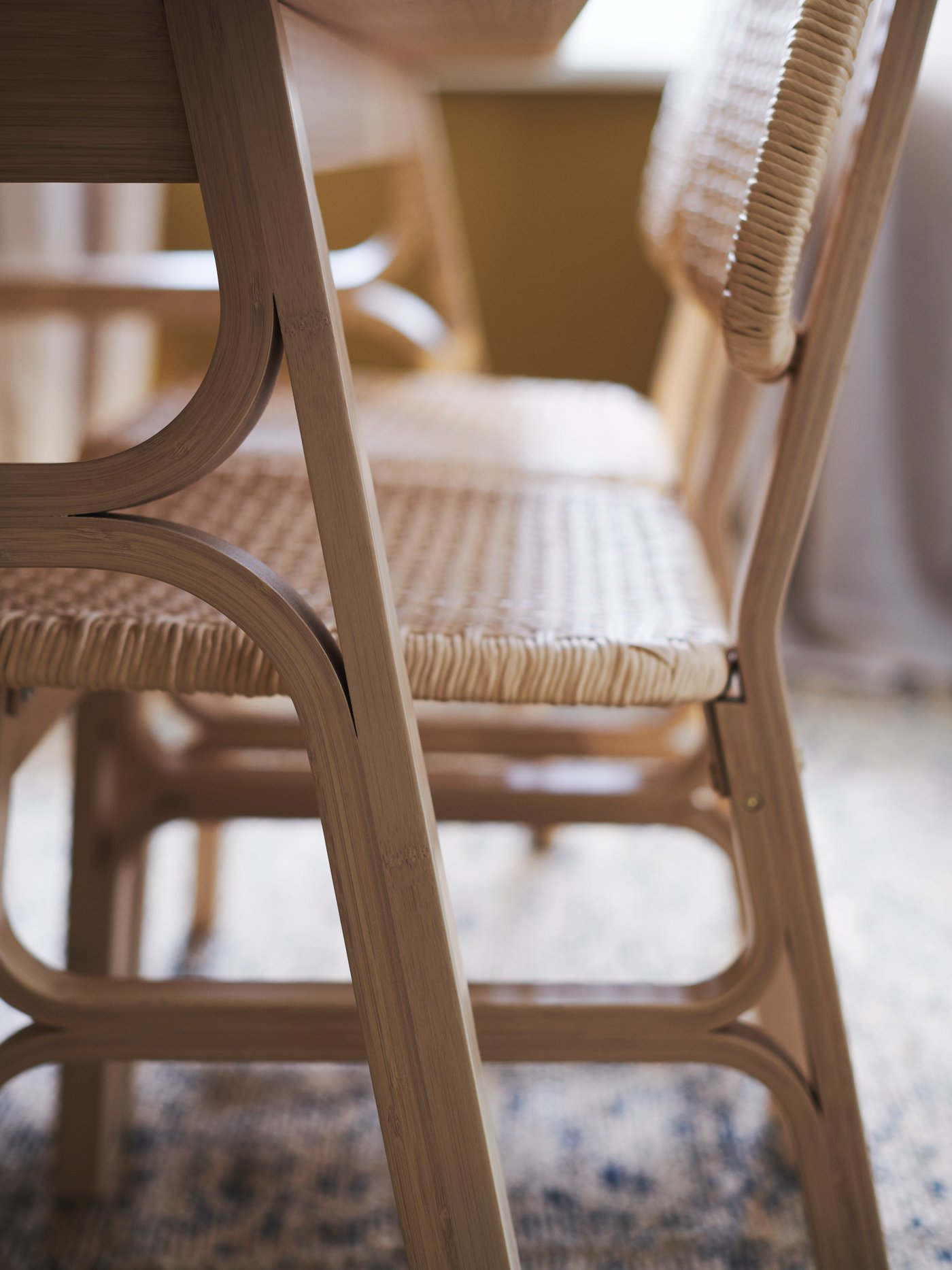 كراسي VOXLÖV لها أرجل من الخيزران بها تفاصيل منحنية بطريقة جذابة ومقاعد منسوجة يدوياً ومساند ظهر من خيوط مجدولة من الورق.