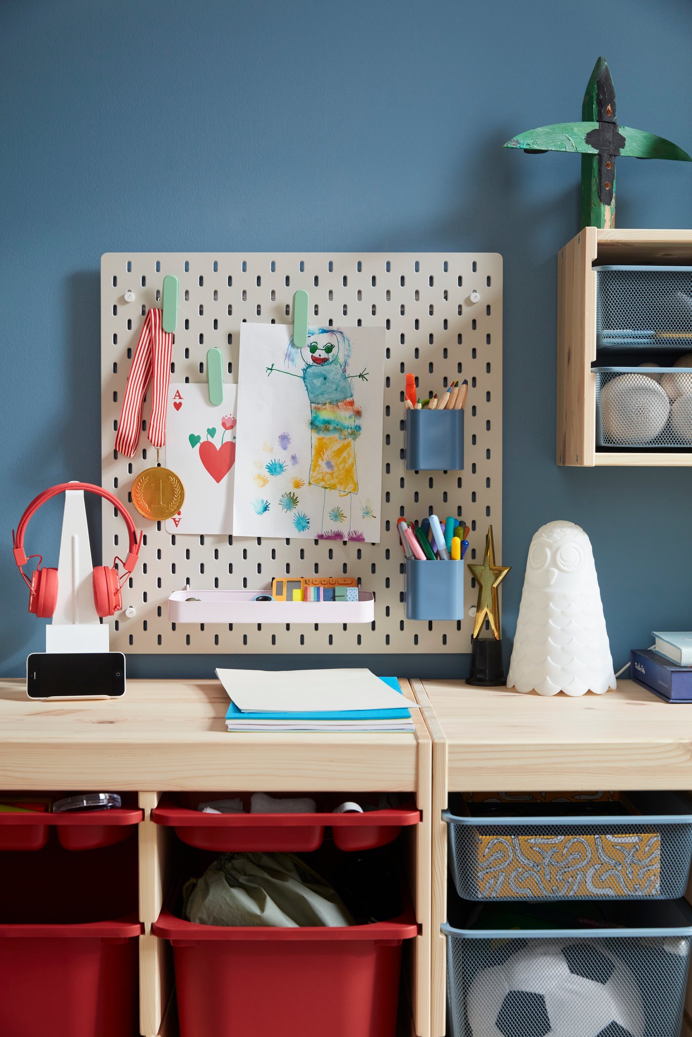 A grey-blue TROFAST mesh storage box in the childrens room