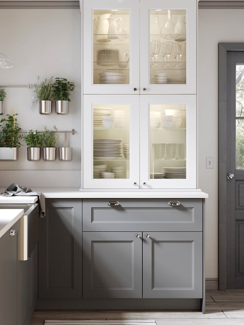Kitchen with glass door cabinets, base cabinets with drawers and doors, a custom made worktop, and two rails with containers. 