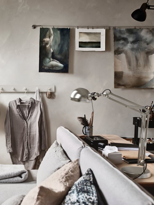 Spațiu de lucru modern cu birou din lemn care susține o lampă de lucru flexibilă din oțel placată cu nichel, în stil clasic, și accesorii de birou.